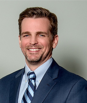 Headshot of Dr. Jared Nimitz wearing a blue suit and necktie