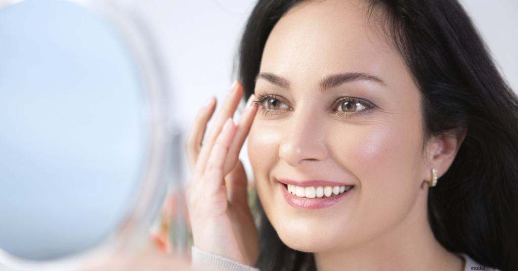 portrait of woman admiring skin in mirror